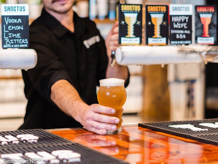Pouring beers for visitors at Sanctus Brewery