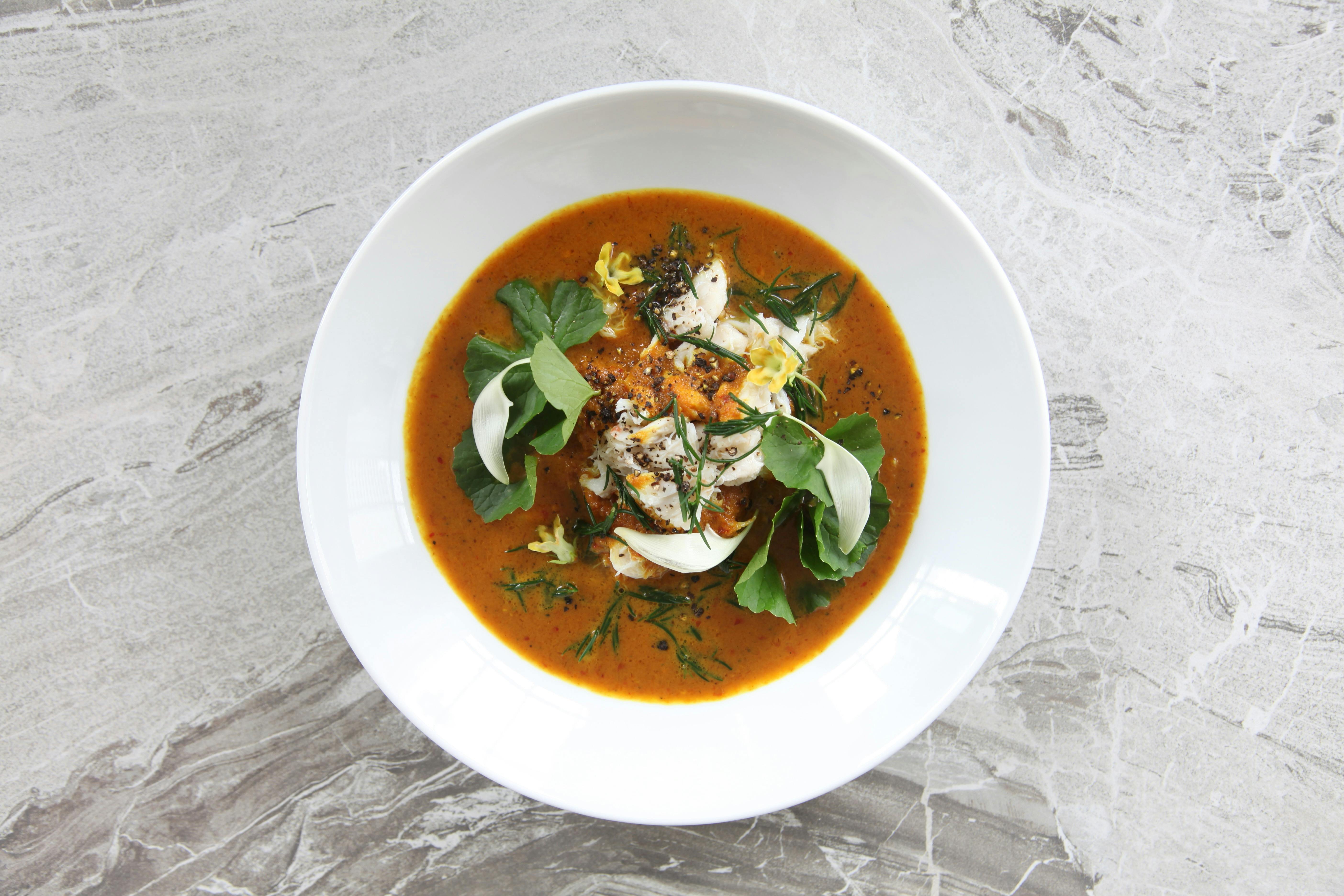 Smoky southern yellow curry of Gulf of Thailand red spanner crab, hummingbird flowers, Thai samphire