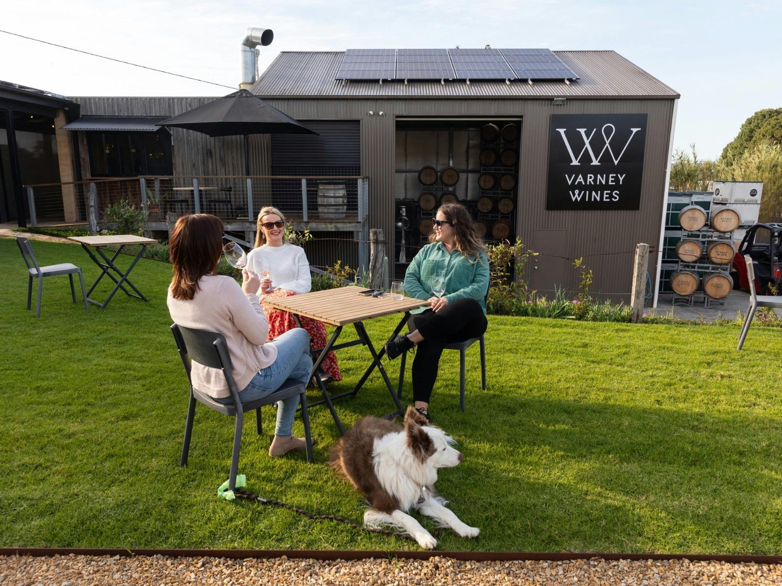 Guests enjoying a glass of wines on the lawns with their dog