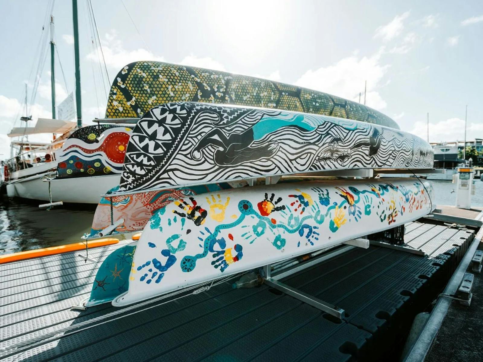 Canoes with artwork stacked at a marina Canoes with artwork stacked at a marina