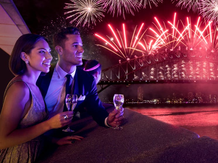A couple watch the fireworks over Sydney Harbour on New Year's Eve