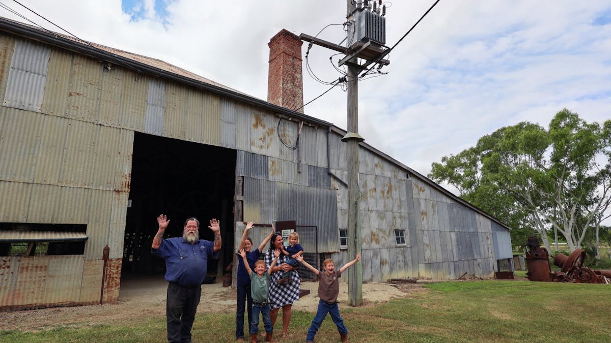 Our tour guide and guests outside the Venus Gold Battery Smiling with hands in the air