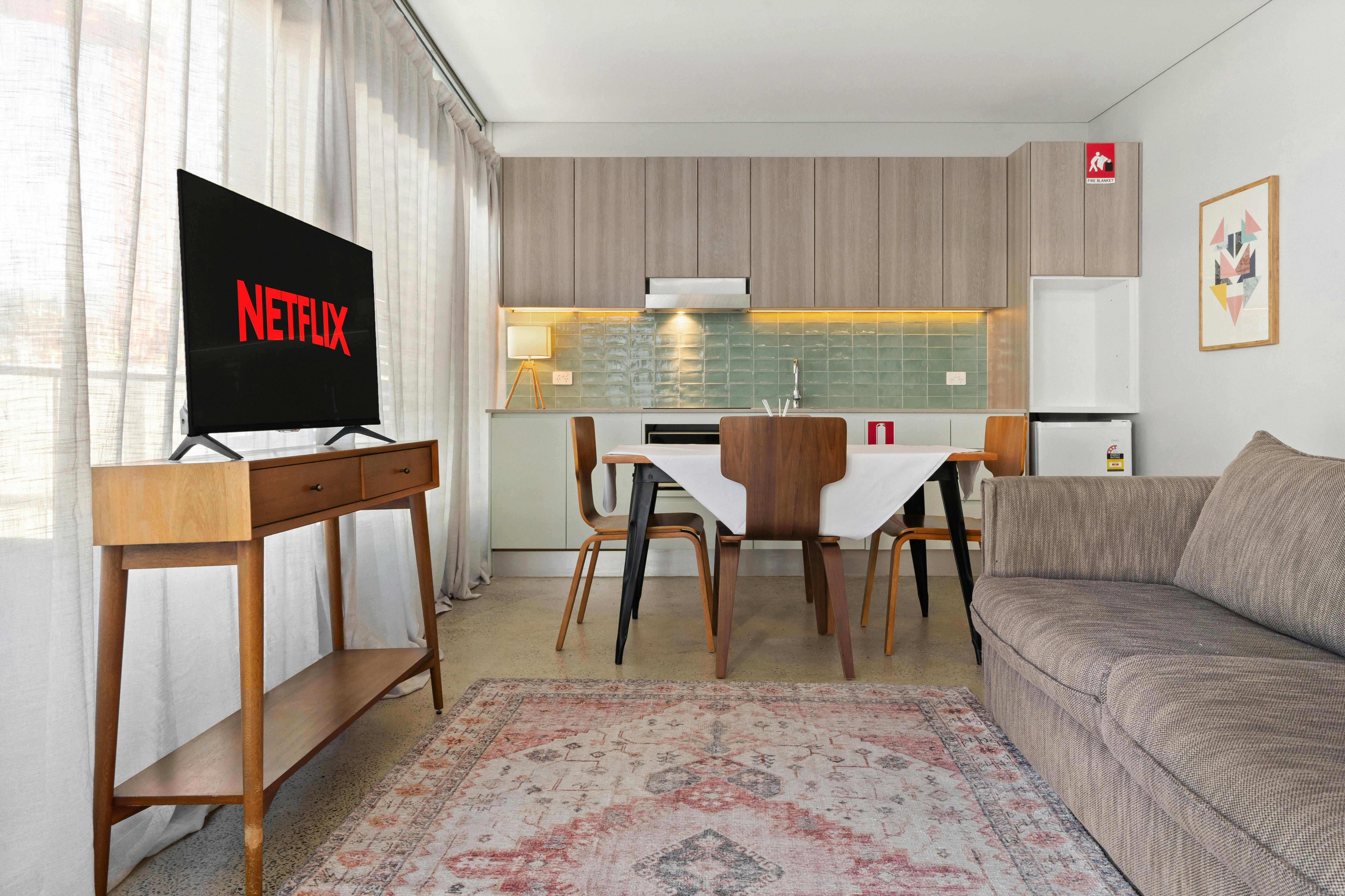 발코니에서 보이는 아파트 풍경에는 식사 공간 소파, TV가 있습니다.