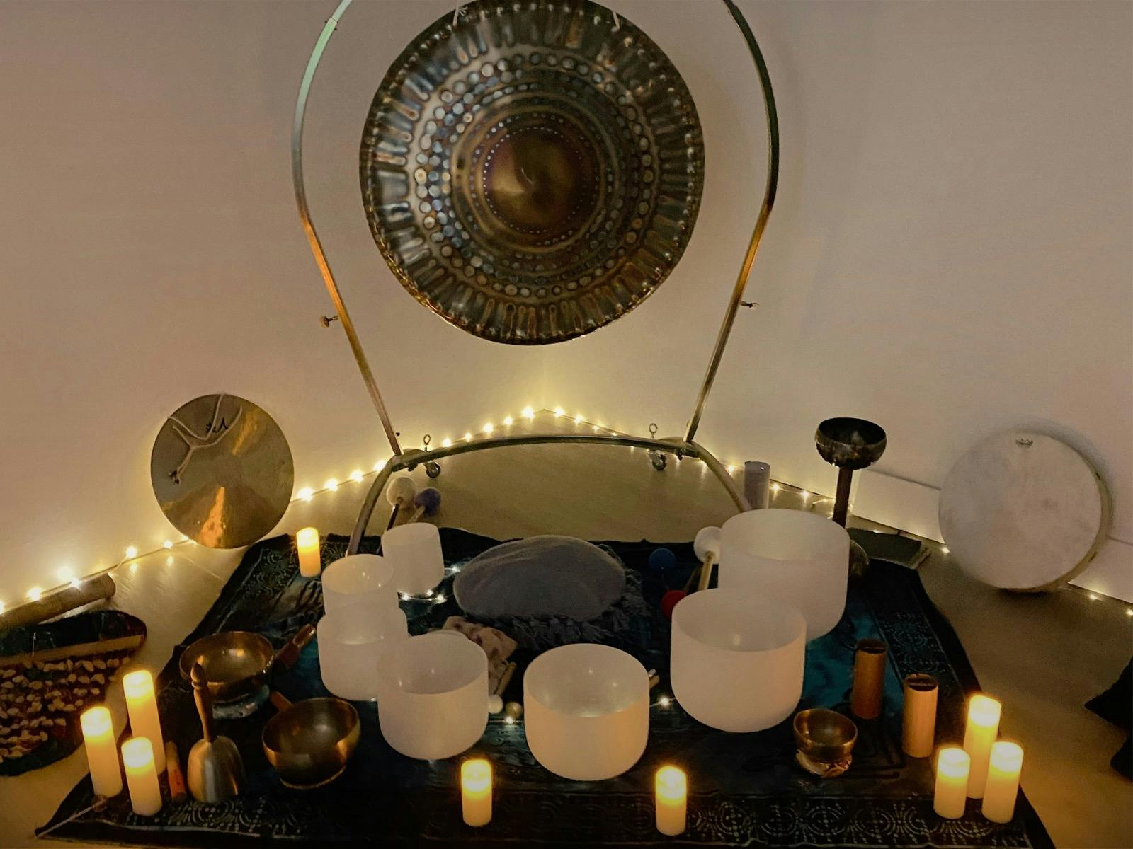 Photo of sound healing instruments set up for a sound bath - singing bowls, gongs, drum, chimes.