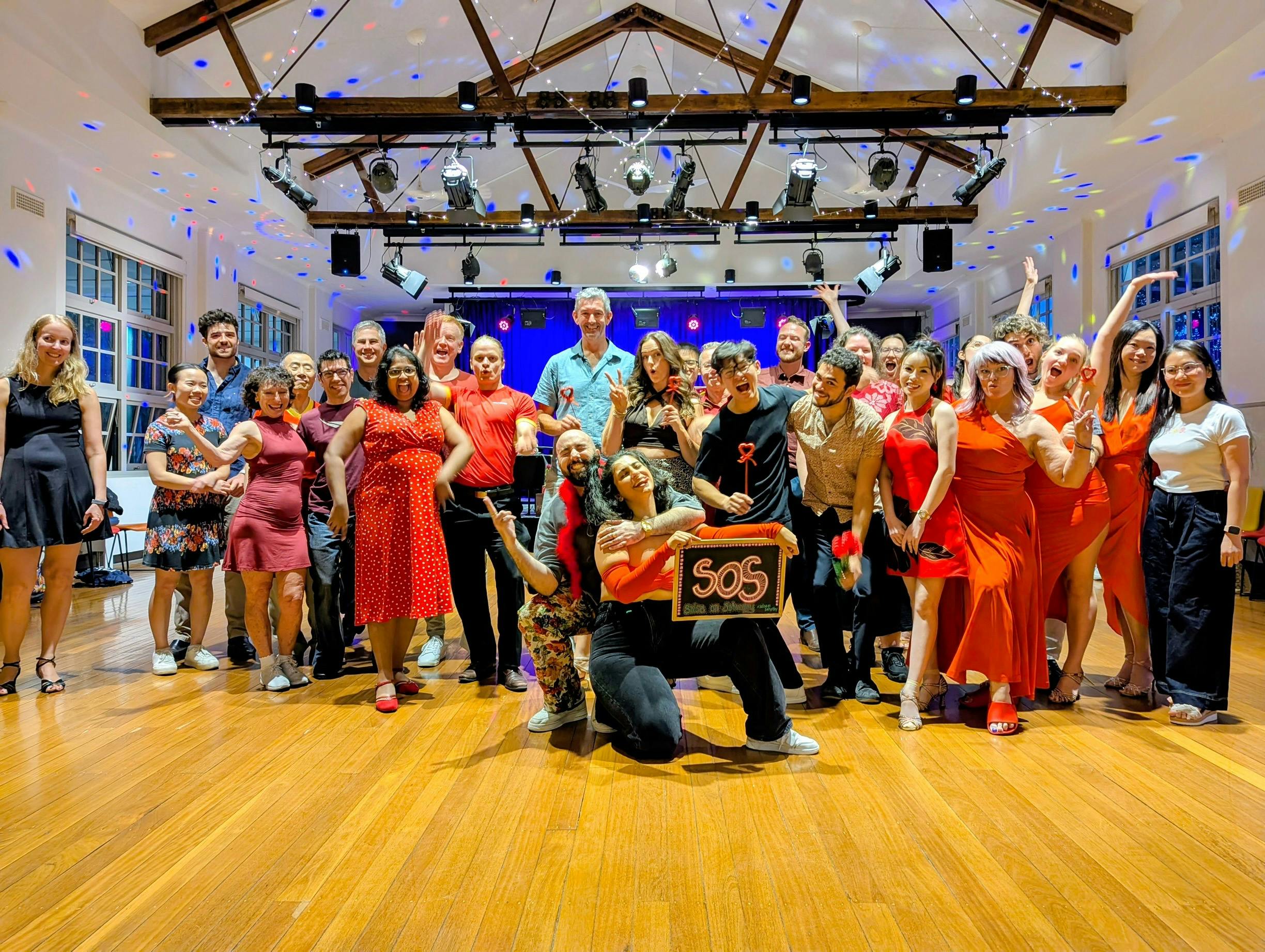 A group of social dancers dressed in for a photo following a dance workshop