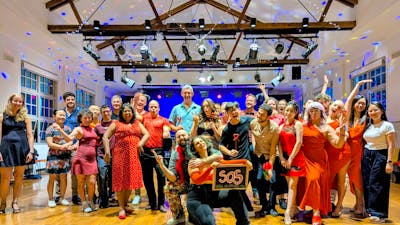 A group of social dancers dressed in for a photo following a dance workshop
