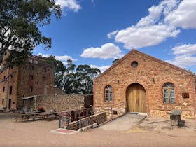 a historic old shearing building with an old but renovated brewery tower in the background