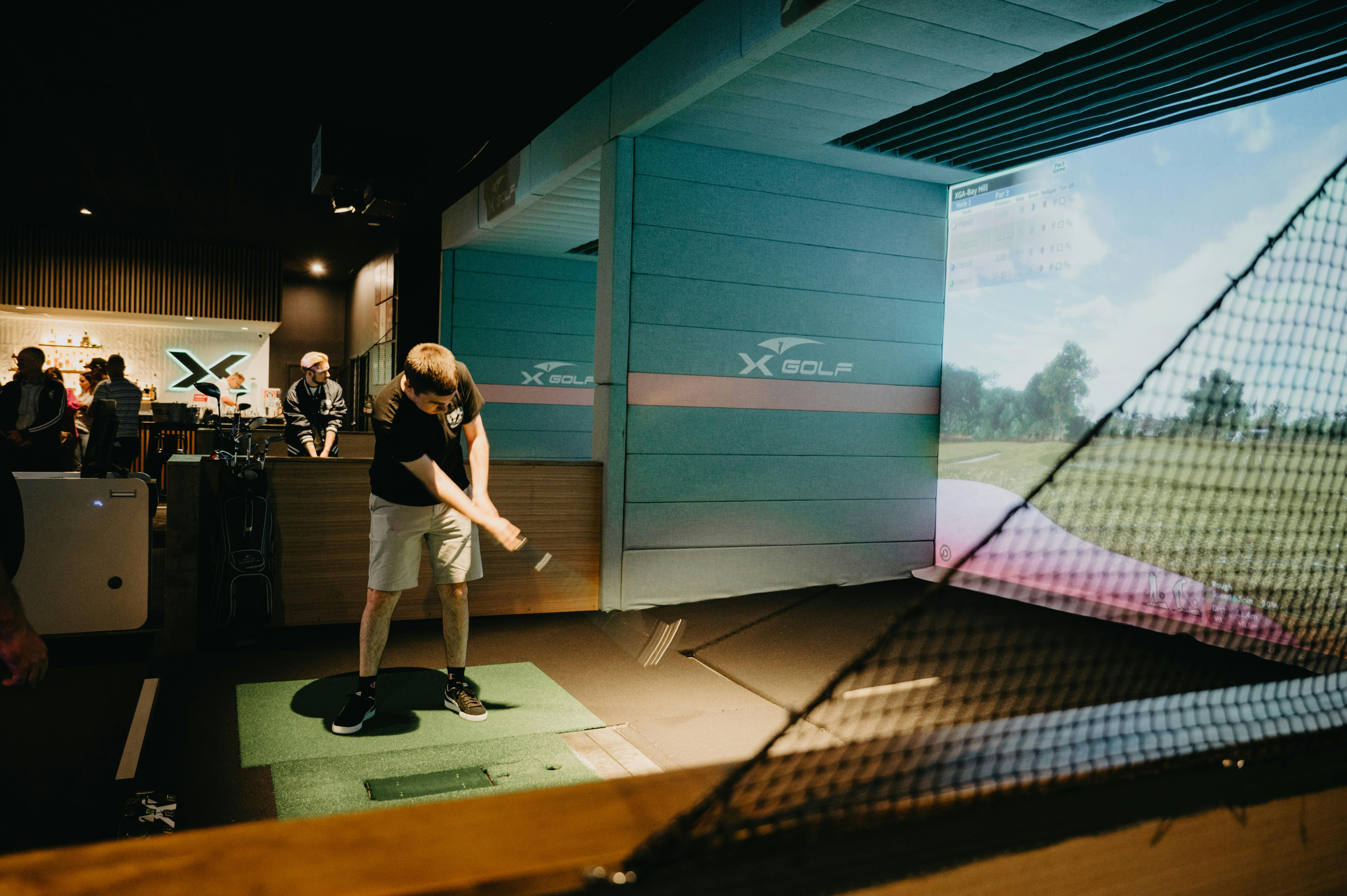 Man playing Indoor Golf Simulator at X-Golf Macarthur Venue