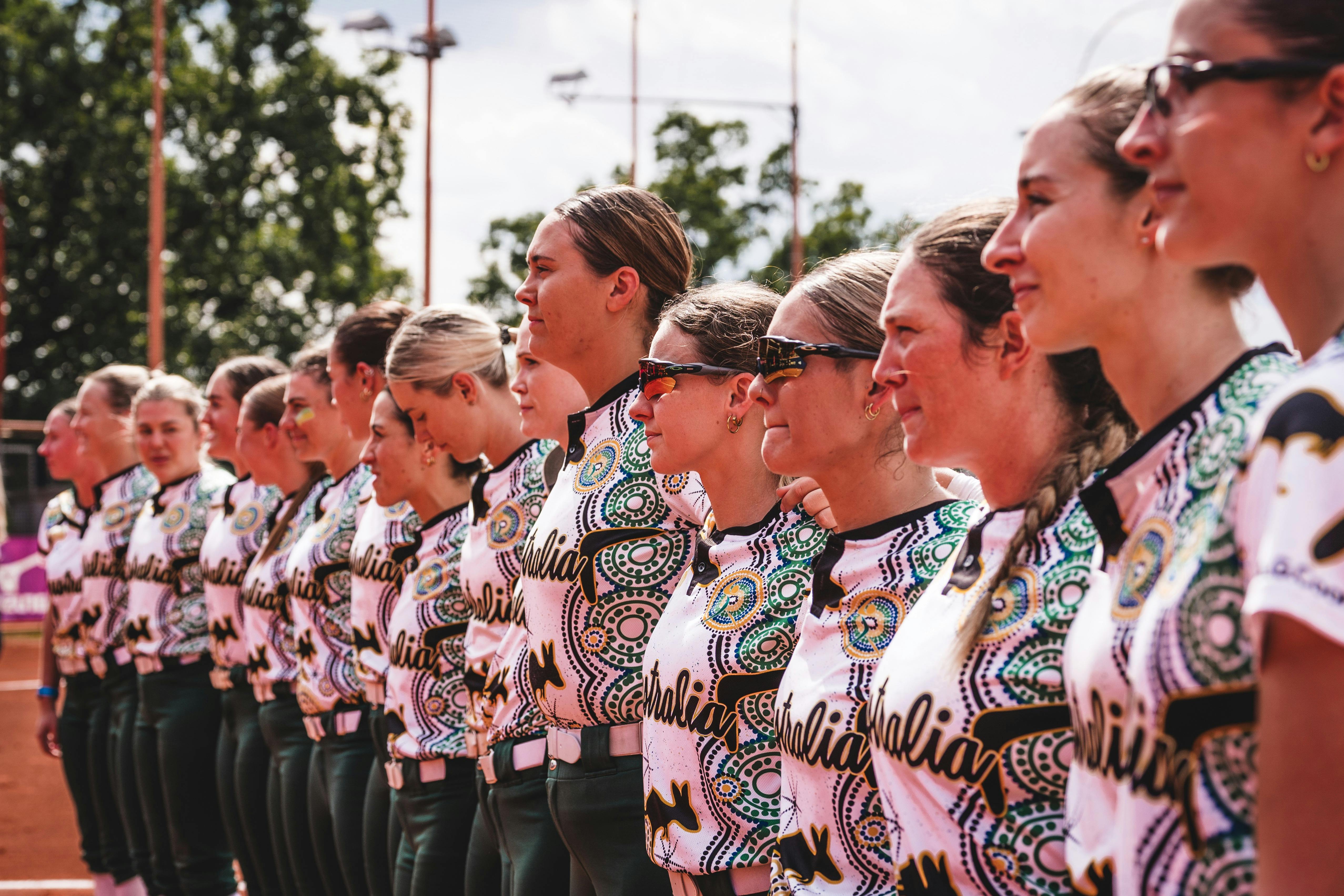 Australian softball team lines up on field in Indigenous-inspired uniforms before international matc
