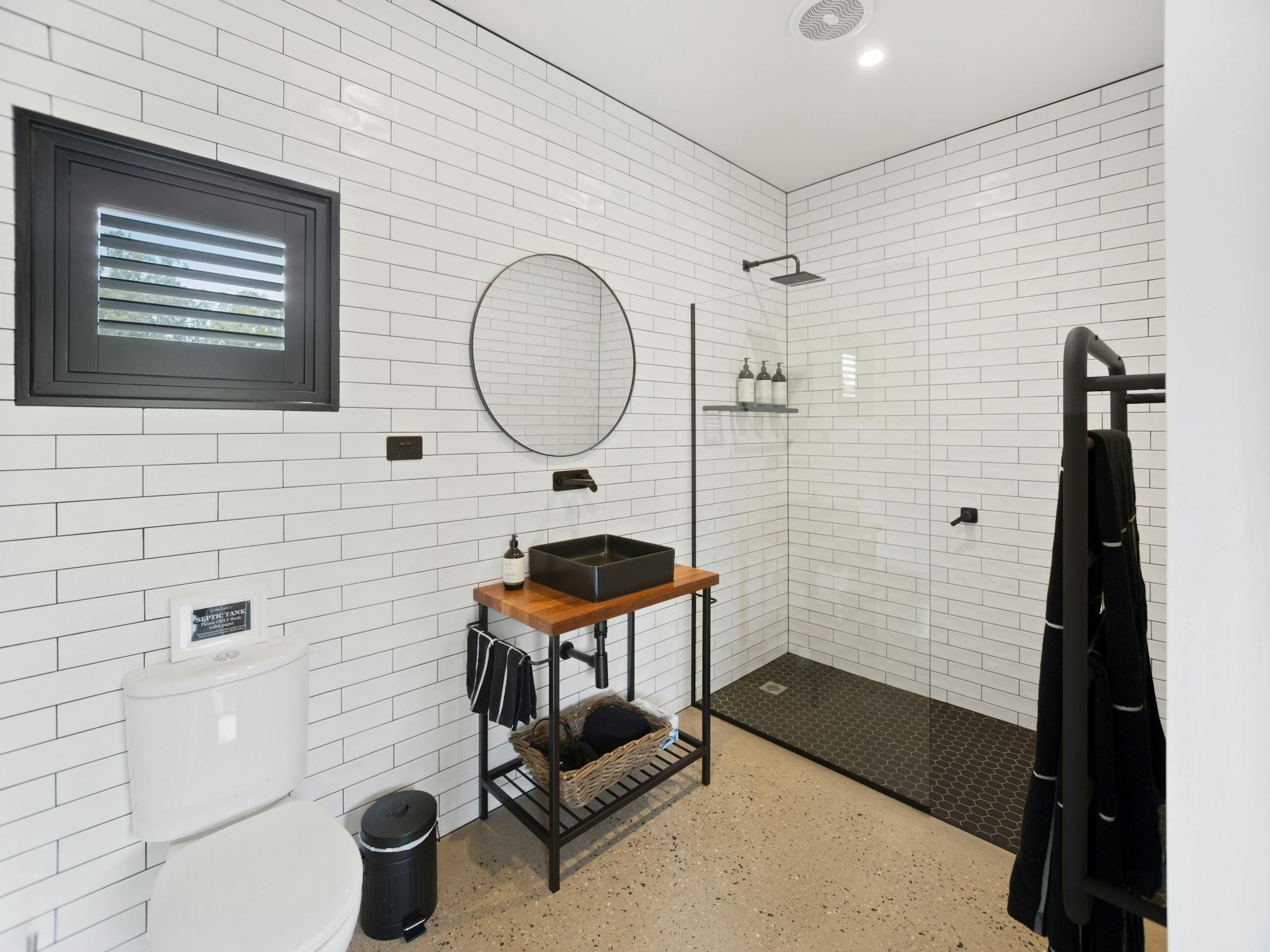 Full sized en-suite with white  subway tiles, black grout and fittings, marimekko towels