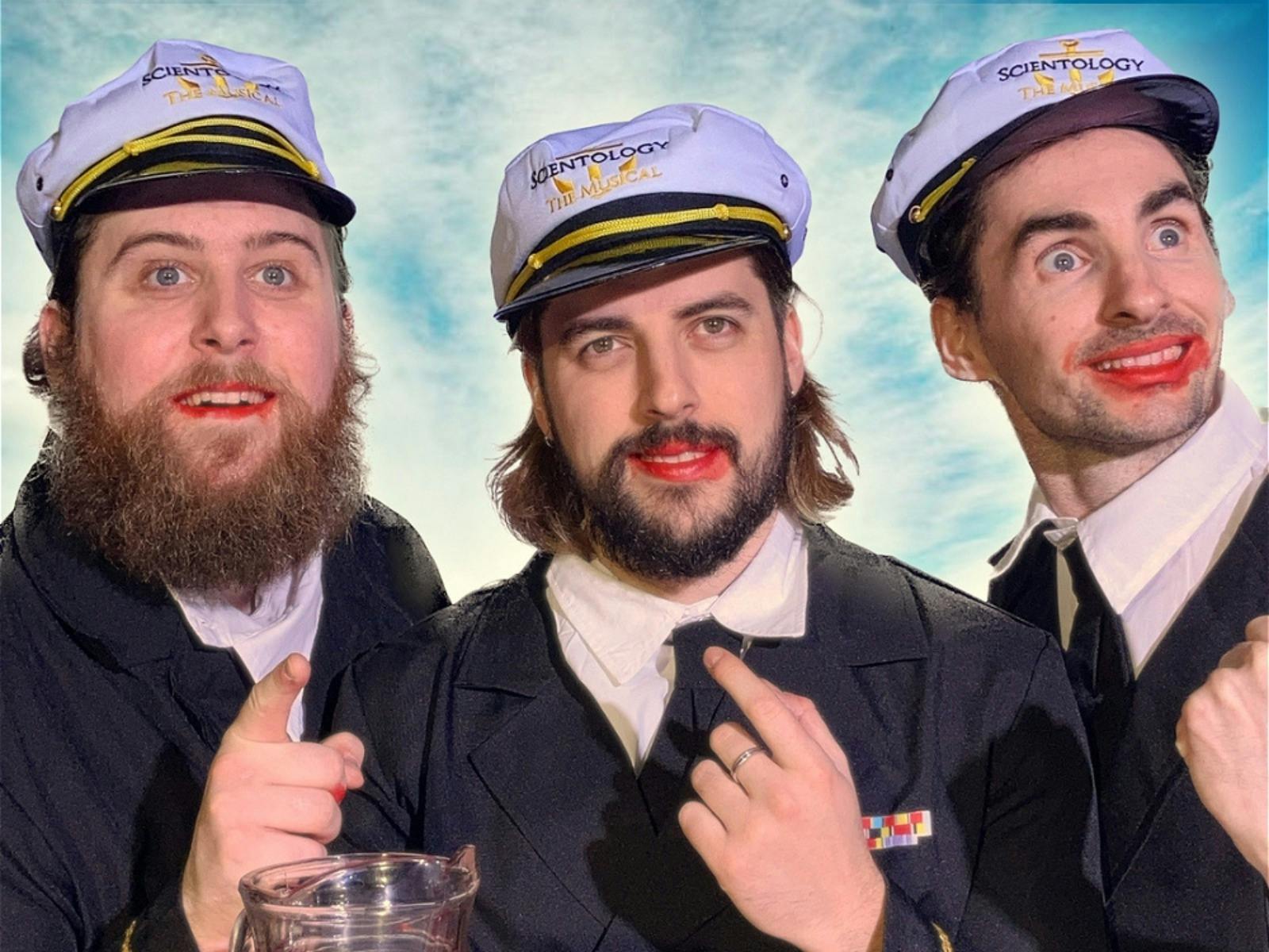 three men dressed as sailors, one with lipstick