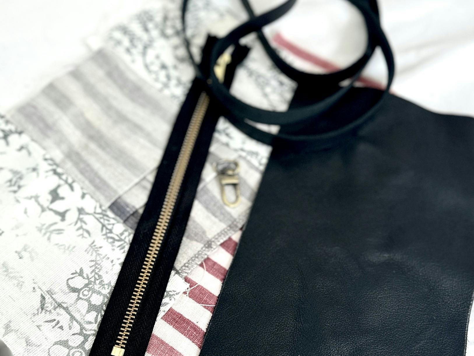 Leather clutch materials laid out, including black leather, a gold zipper, a leather strap, and a mi