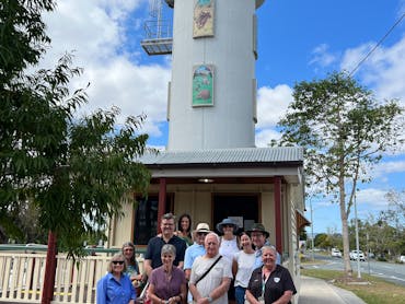 A guide with the walking group tour standing in front of the Woodford Visitor Centre