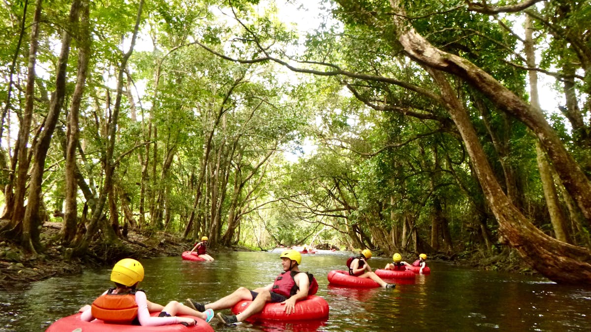 Small group floating down a river surrounded by Wooroonooran National Park rainforest