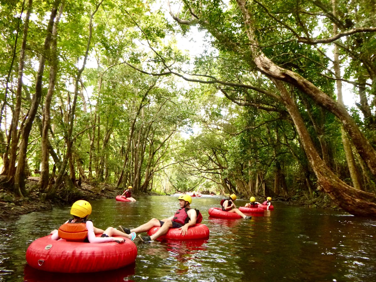 Small group floating down a river surrounded by Wooroonooran National Park rainforest