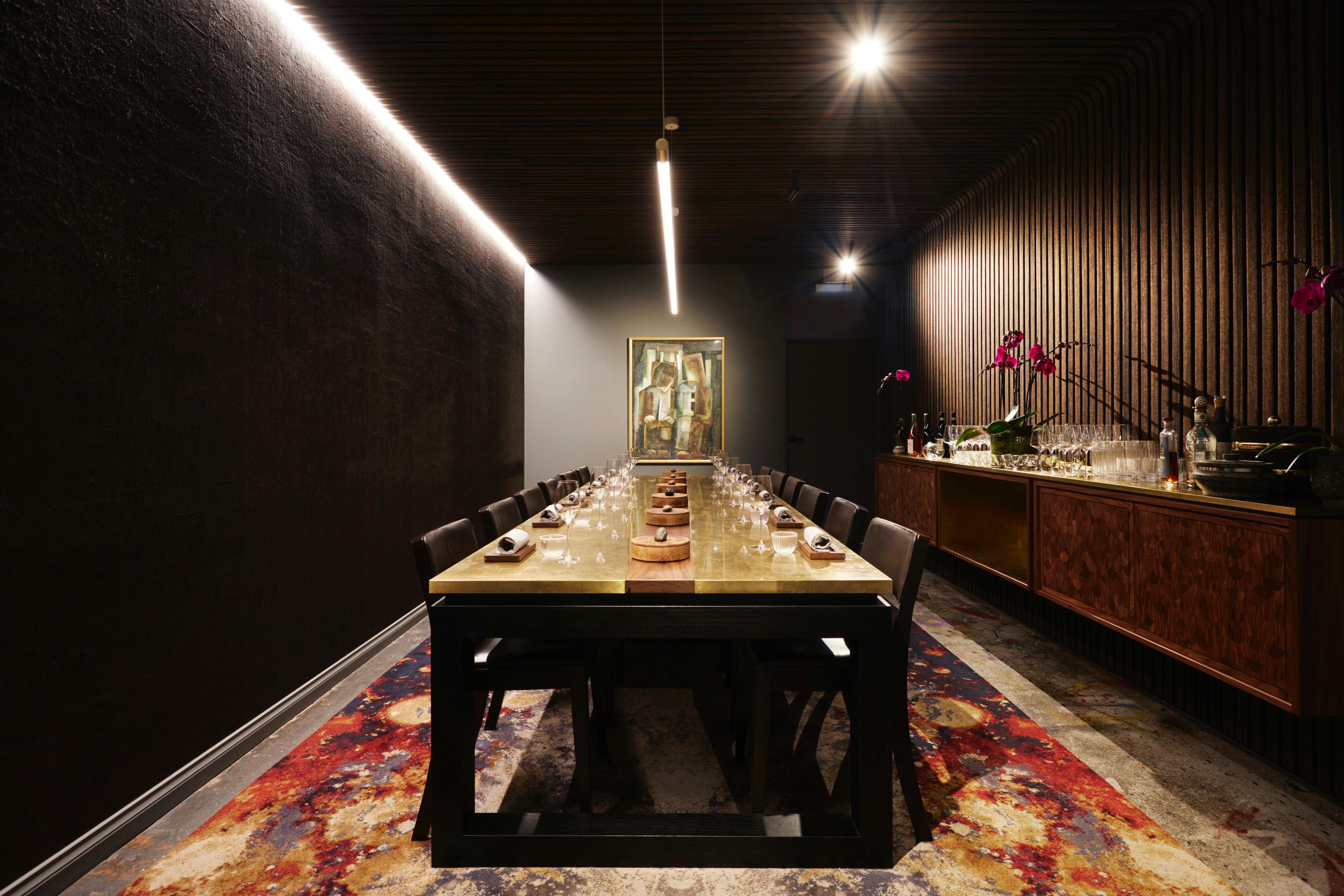 Image of central grand brass table in a dimly lit private dining room