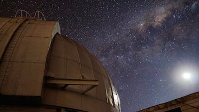 A telescop dome with the Moon and Milky Way Galaxy.