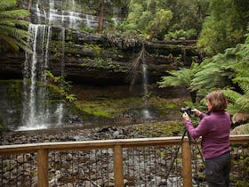 Photographer on tour with Shutterbug Walkbouts taking a photo of Russell Falls in Mt Field NP
