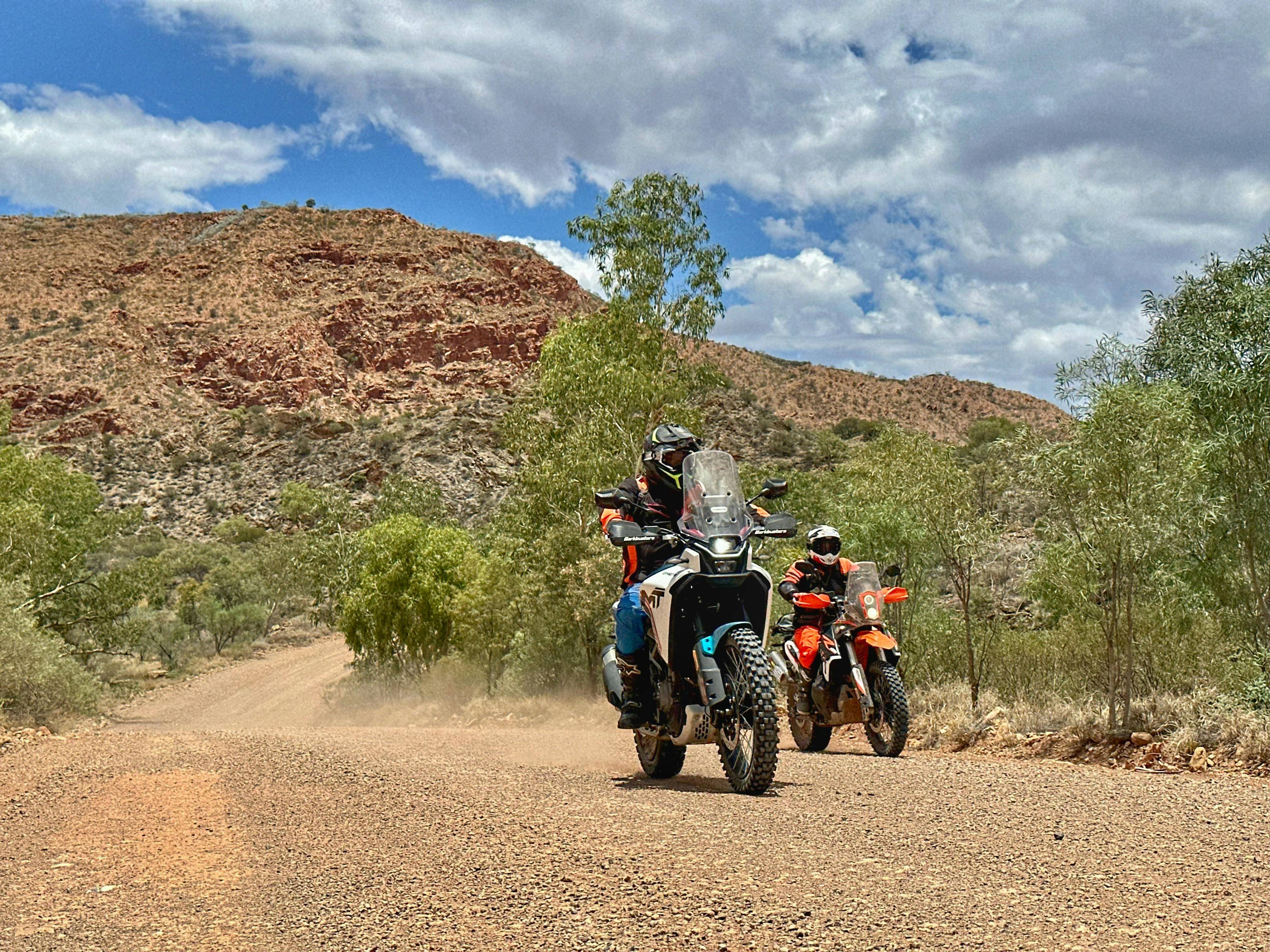 Riders negotiating a scenic dirt road in the Eastern MacDonnell Ranges