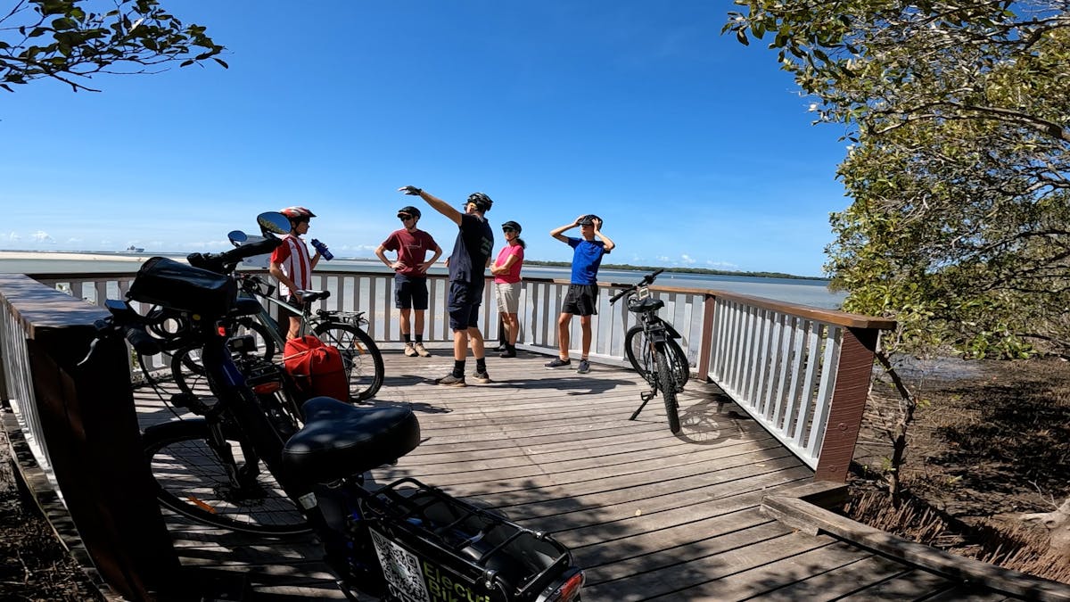 Family of 4 on e-bike tour with marine biologist tour guide, learning about marine environment.
