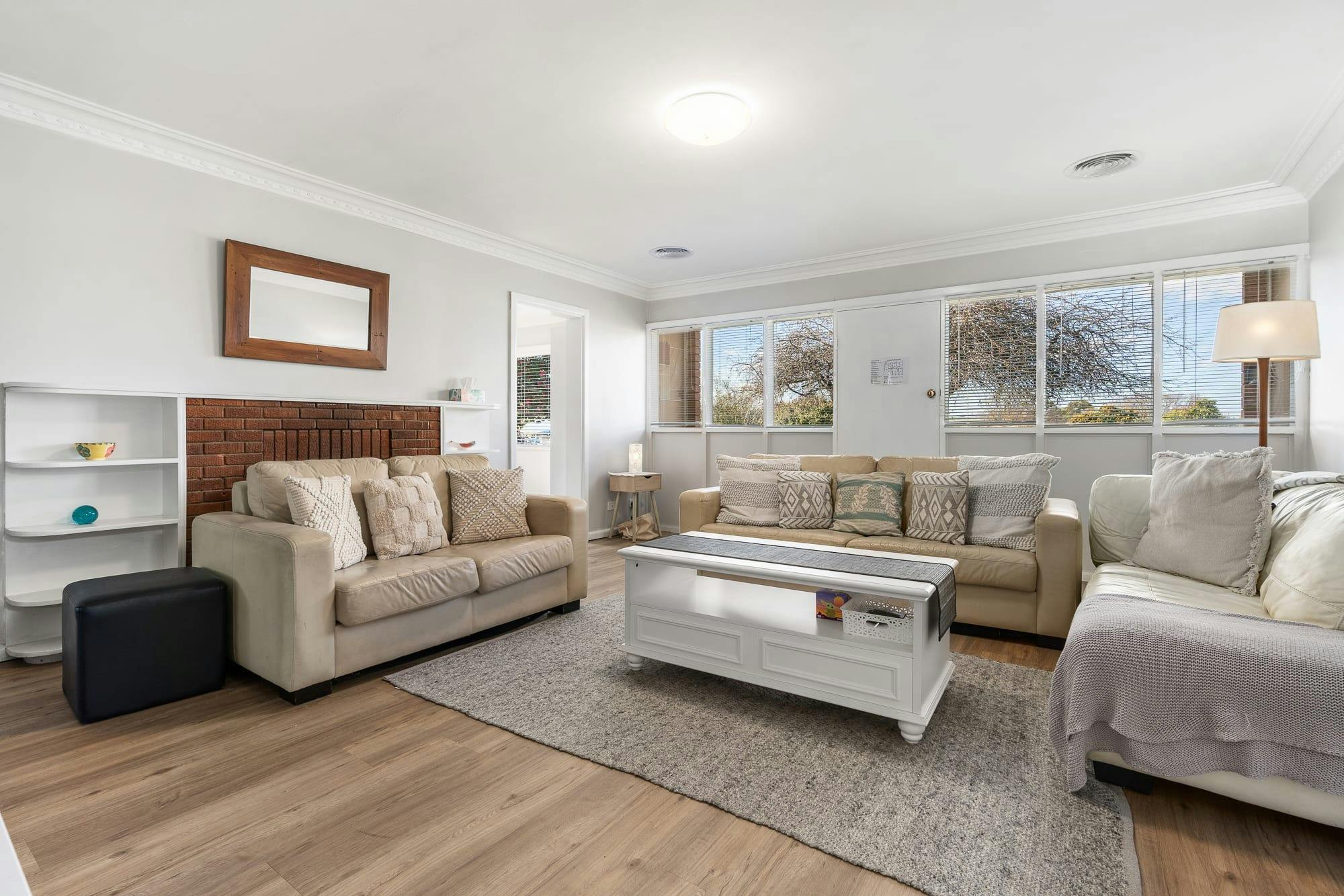 3 comfy couches, rug, coffee table and large winow