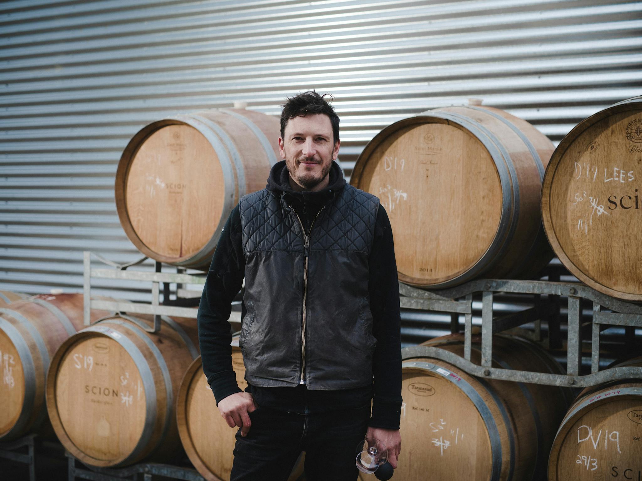 Winemaker standing in front of barrels