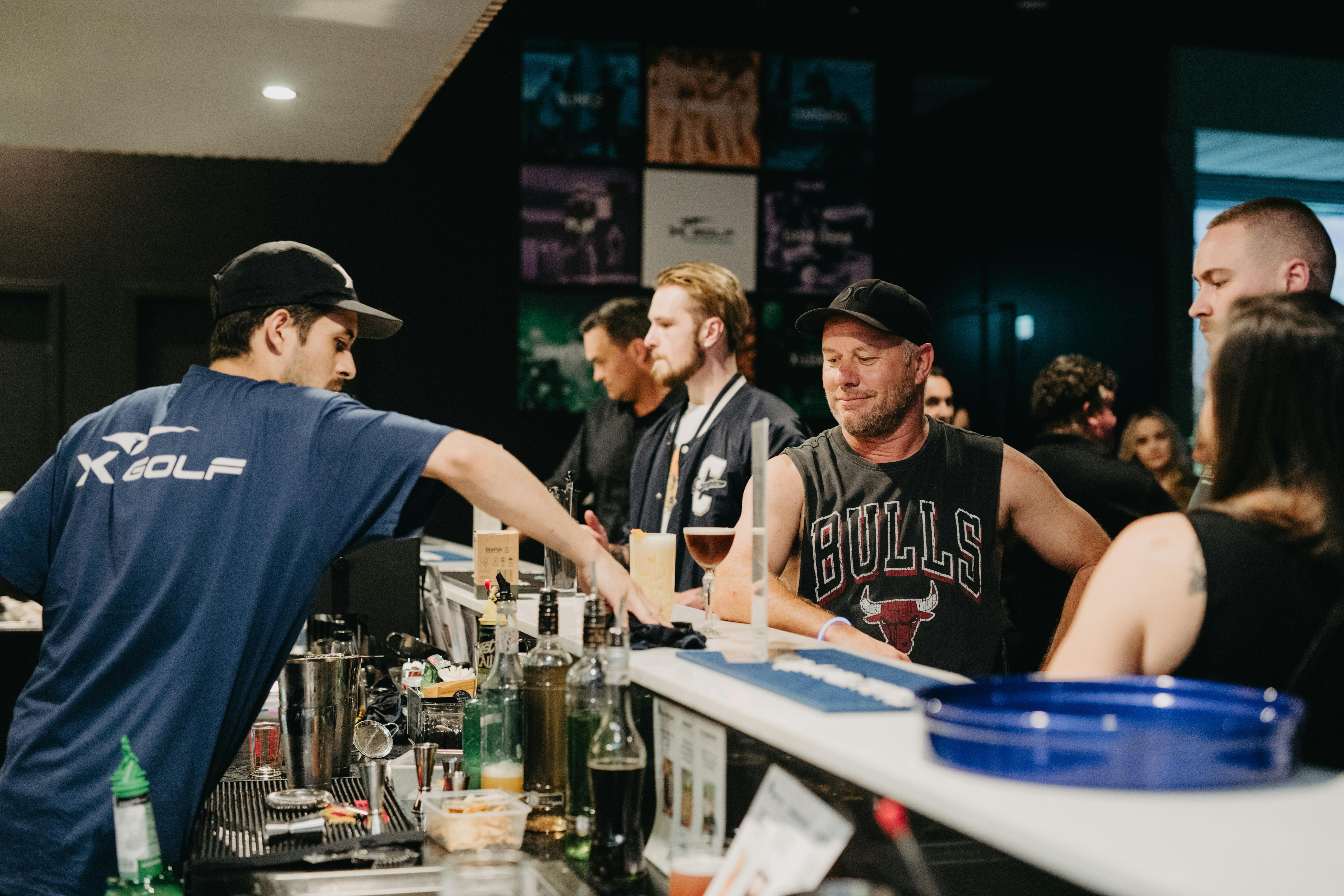 Man serving drinks with customers at Hey Caddy Macarthur