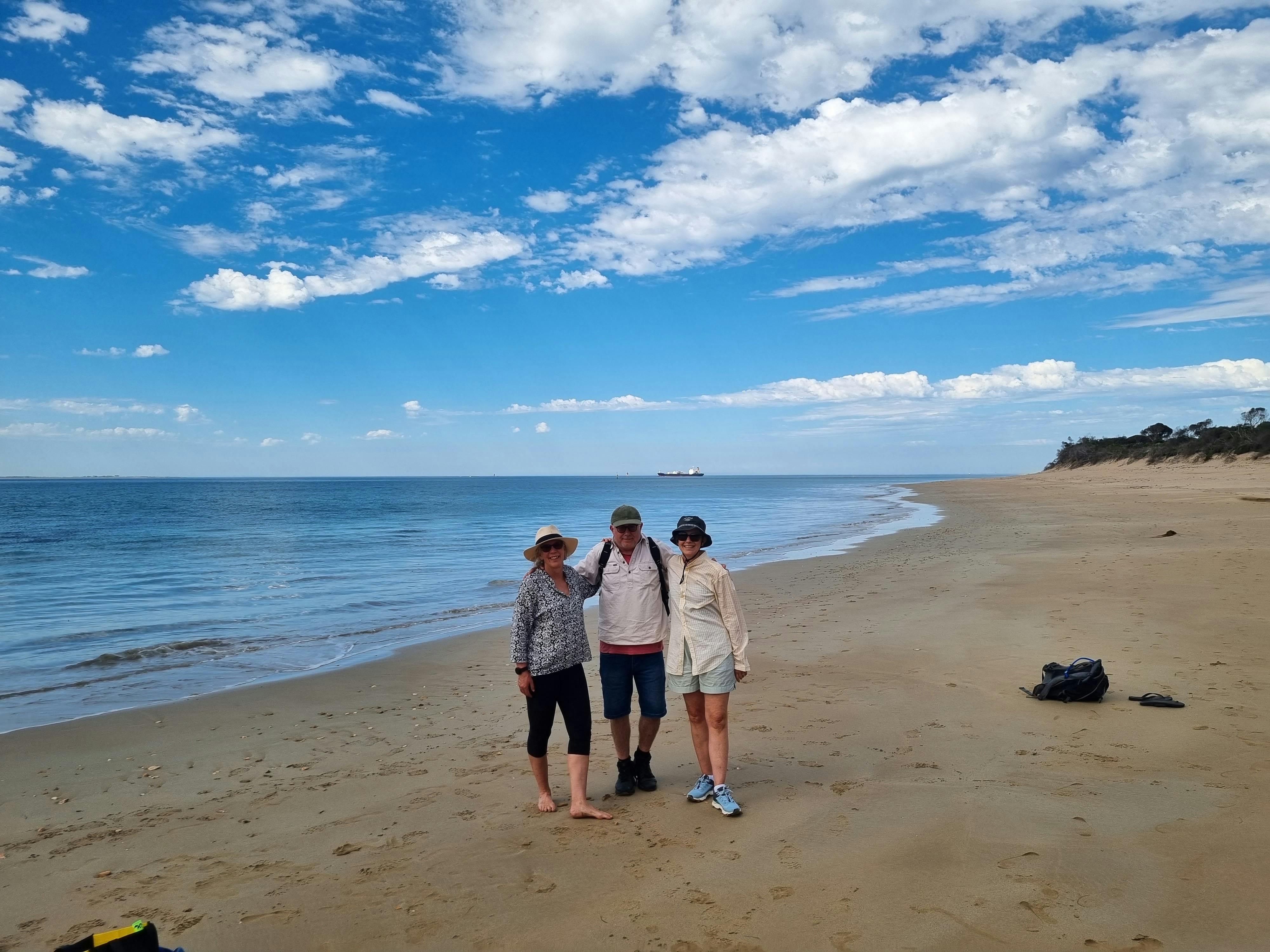 Walkers enjoying the beautiful stretch of golden sand and blue waters of Nepean Bay.