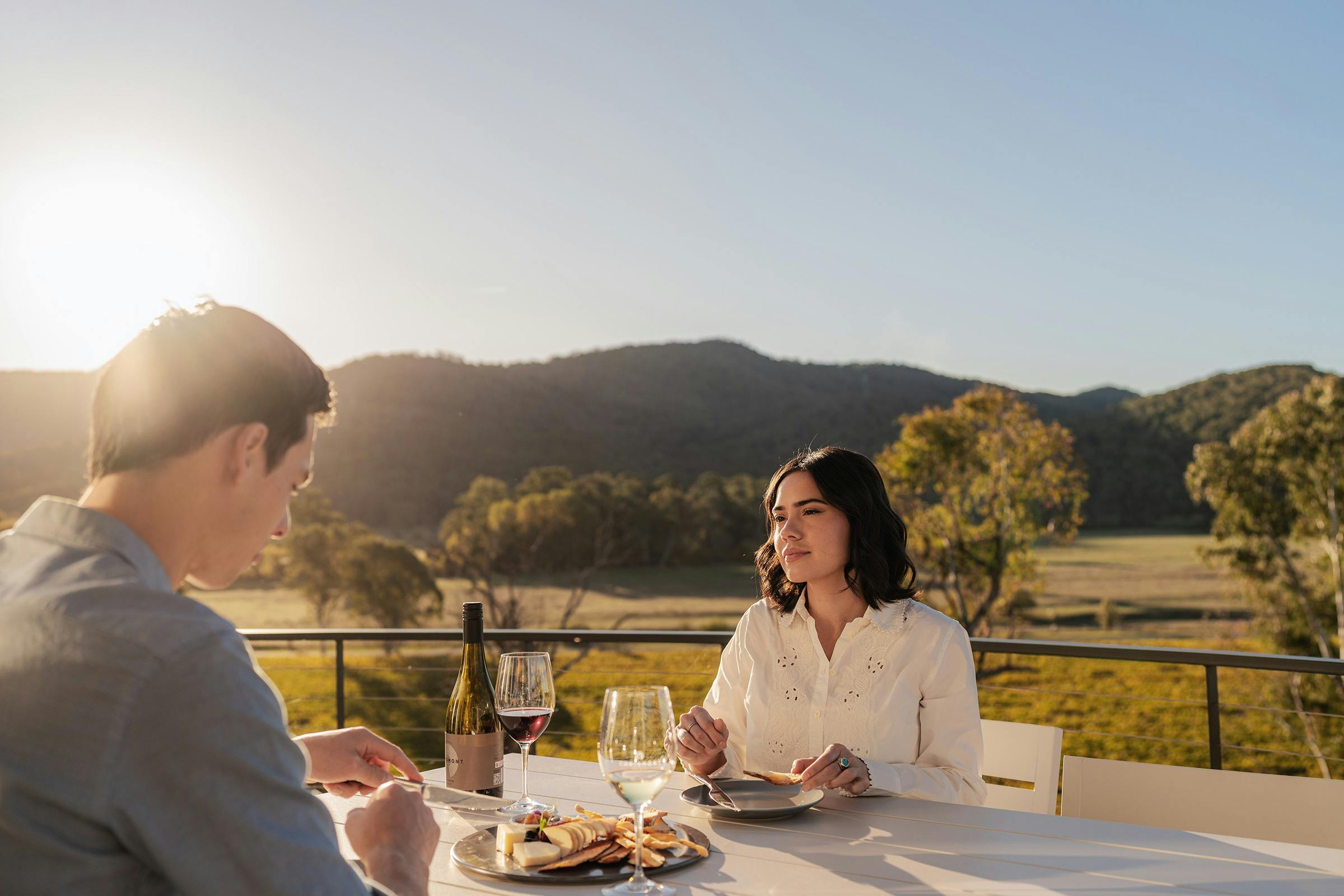 Couple enjoying wine and a cheese platter on the balcony at Retreat Studios at Chrismont
