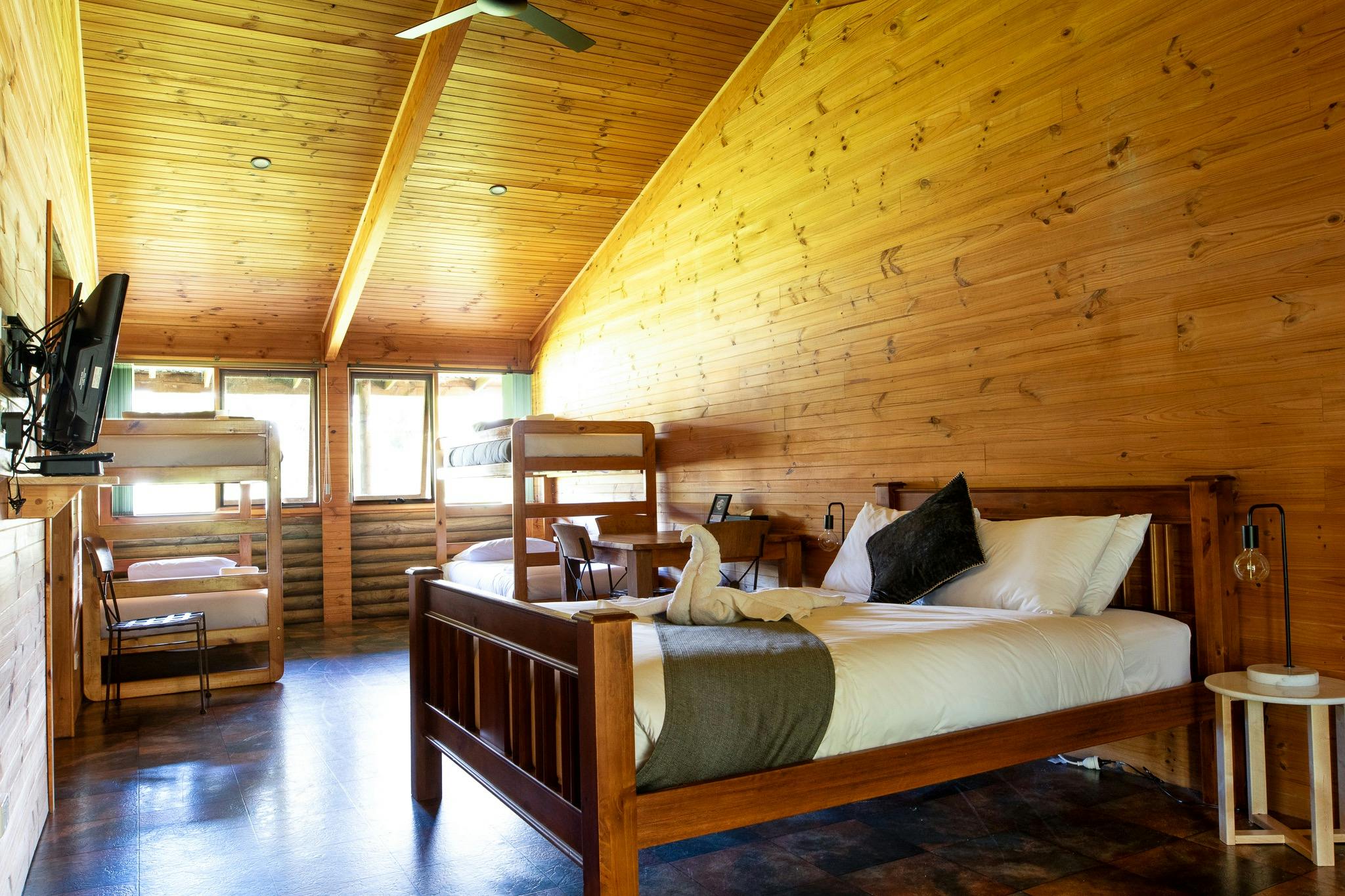 Flat screen TV, Bunks bed and a queen bed in a wooden cabin