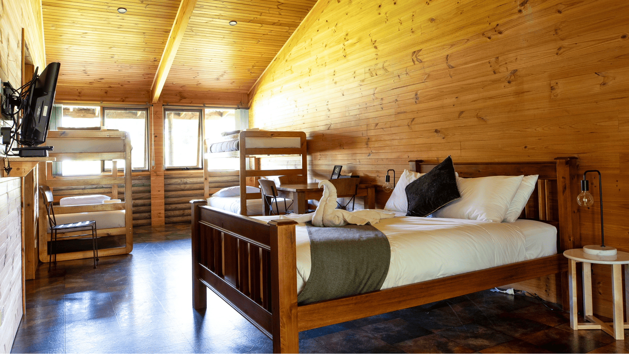 Flat screen TV, Bunks bed and a queen bed in a wooden cabin