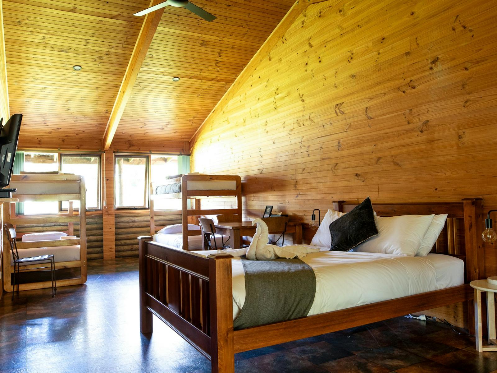 Flat screen TV, Bunks bed and a queen bed in a wooden cabin