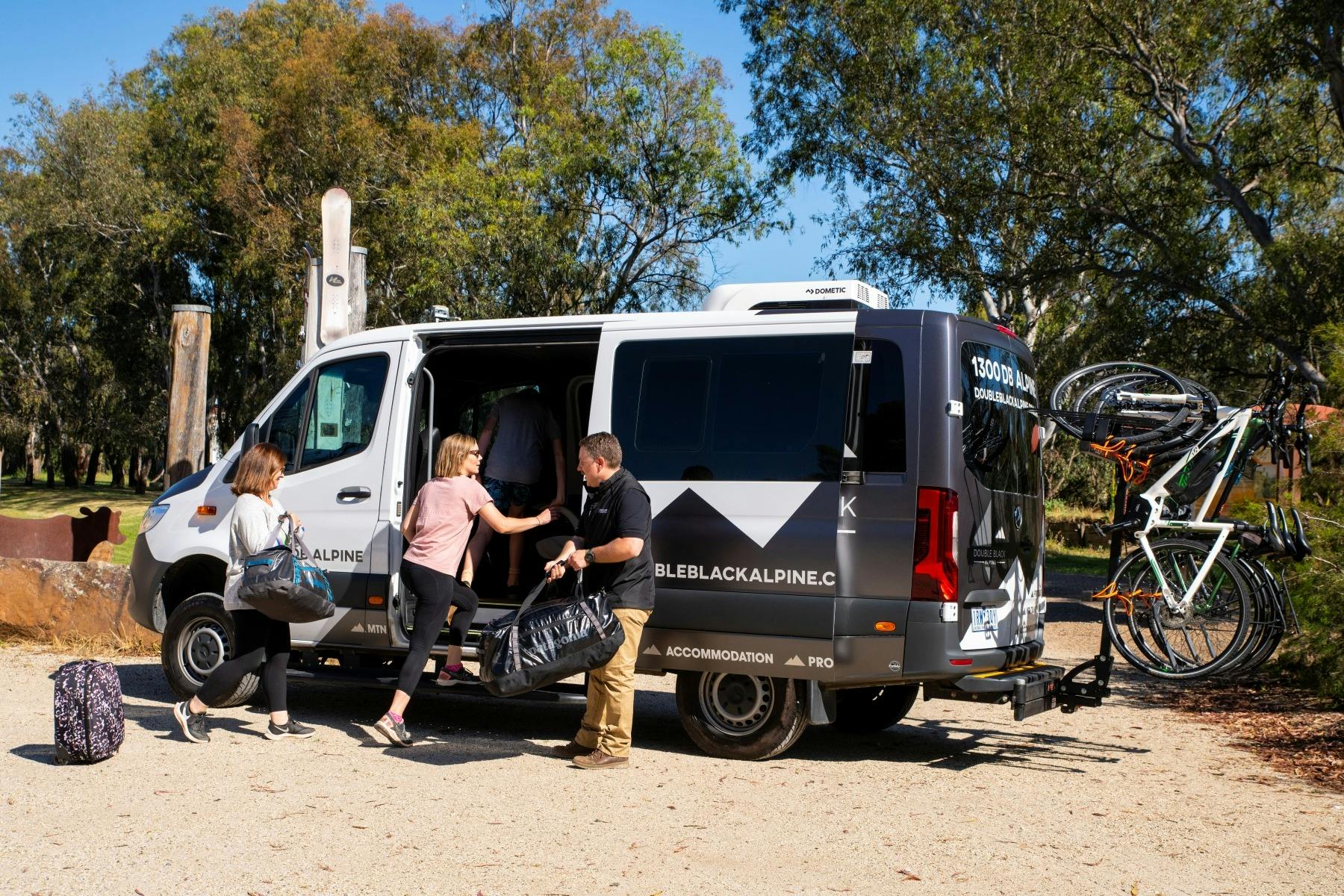 Guests step into the Double Black Alpine passenger van with bikes loaded ready to begin their ride.