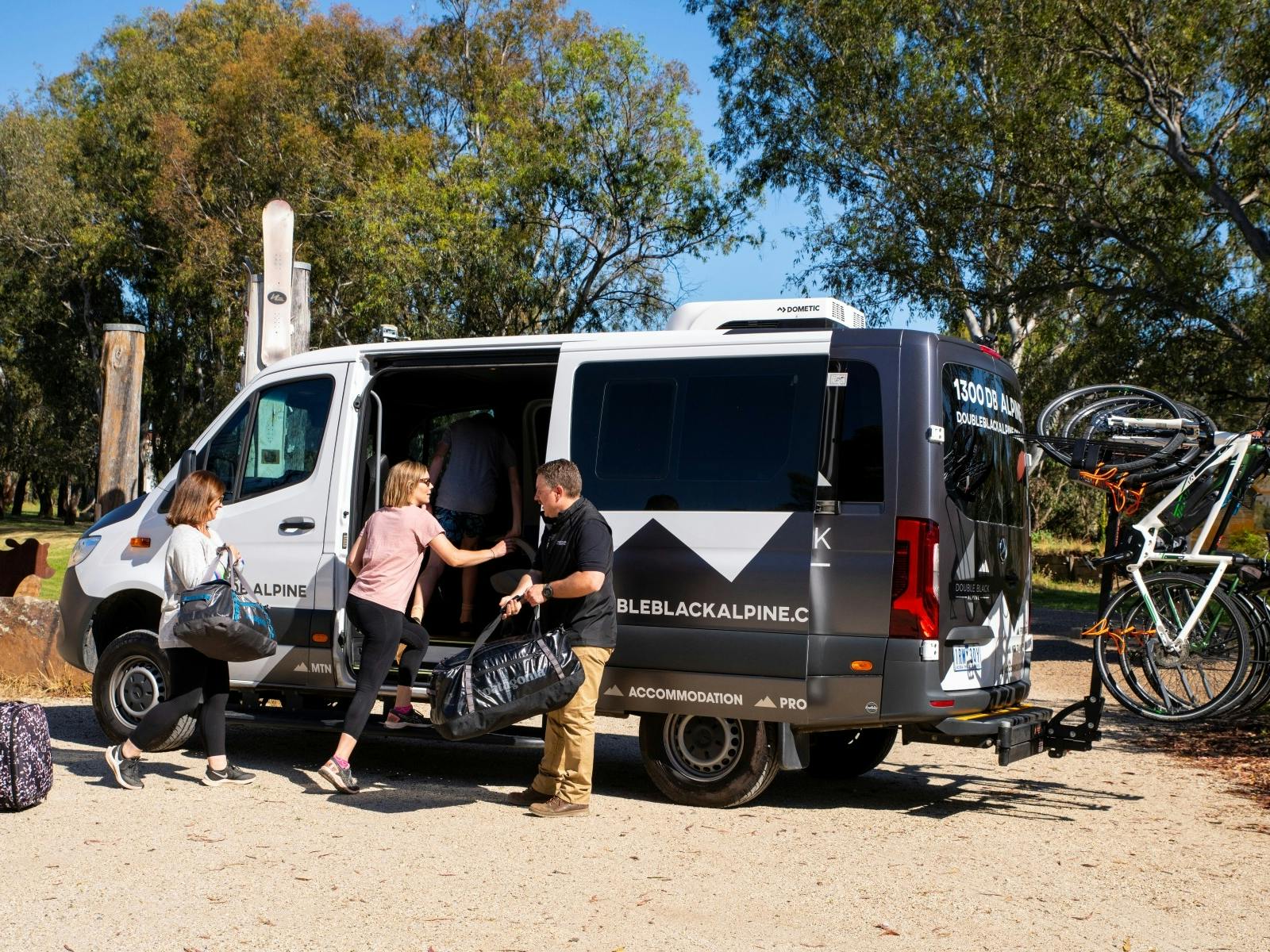 Guests step into the Double Black Alpine passenger van with bikes loaded ready to begin their ride.