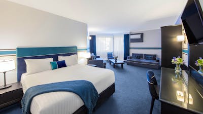 Deluxe King Room bed, working desk and lounge area