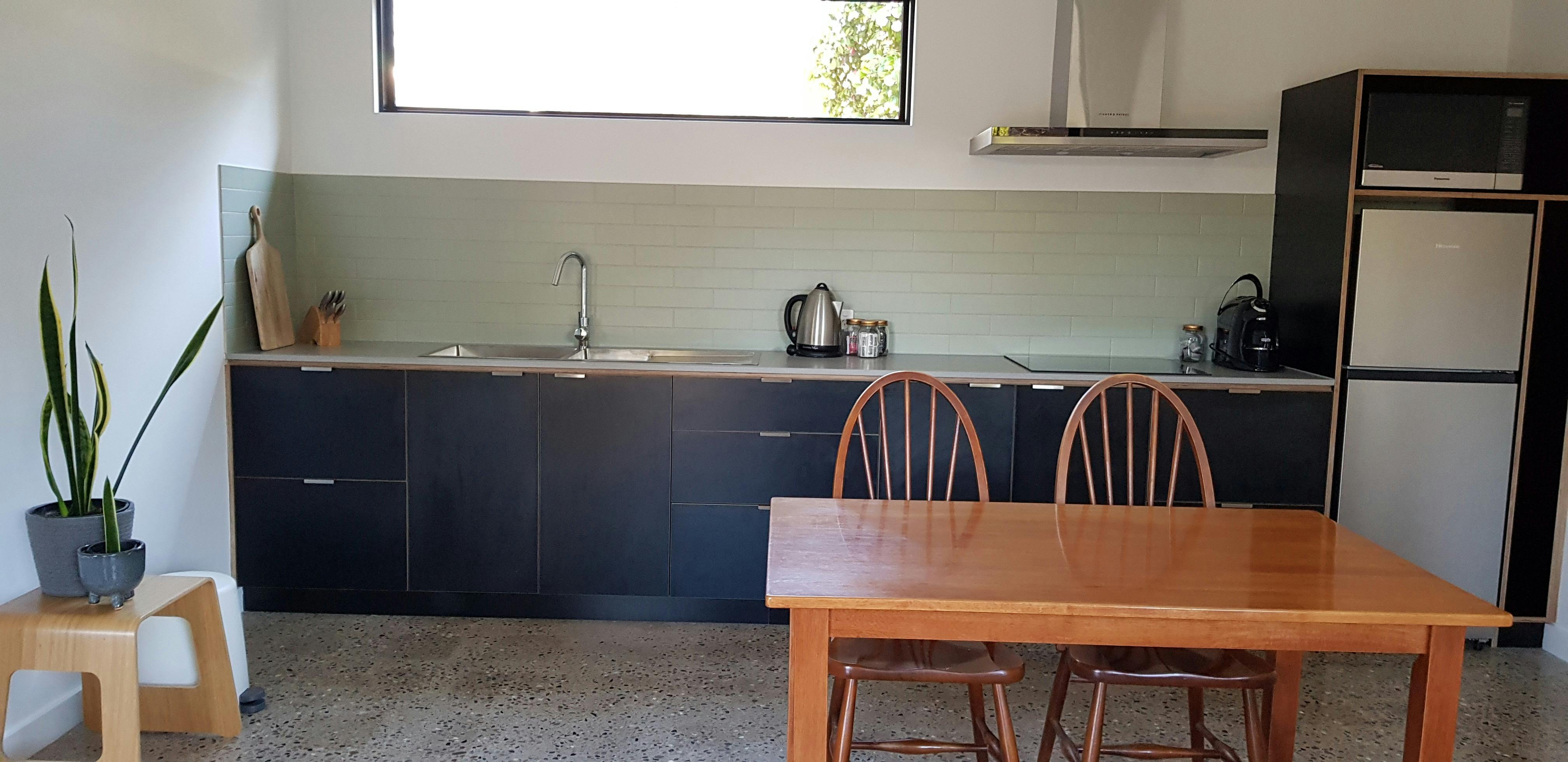 Electric stovetop, large fridge, kettle, toaster, pots and pans, coffee machine.