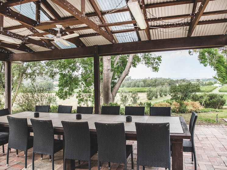 Outdoor dining area includes fire pit, wood fired pizza oven and barbecue