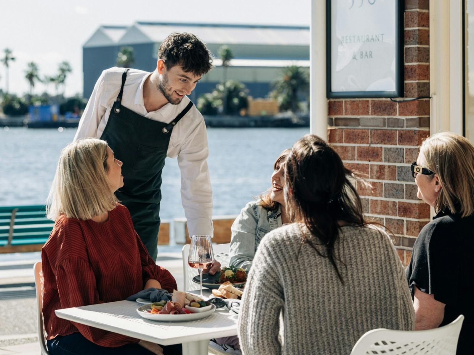 Waiter Serving Food to Group