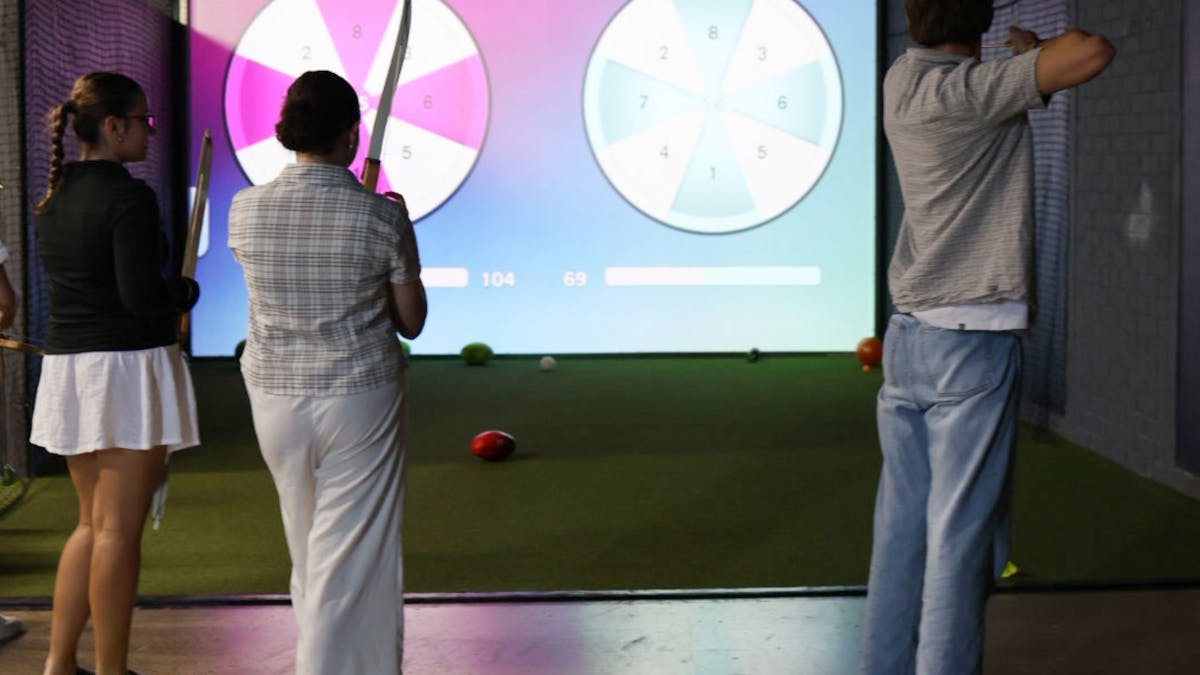 Archery aiming at interactive sports games on an indoor screen at MultiMatch Cleveland.