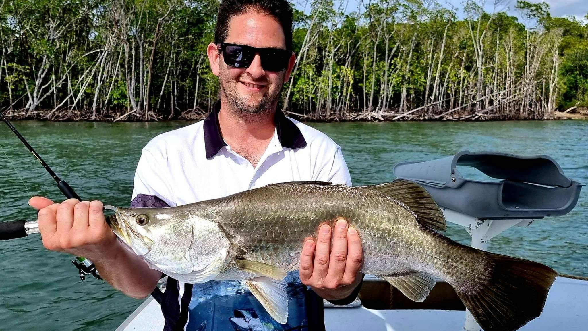 Man holding a barramundi caught with Gone Fishing Cairns on Trinity Inlet Man holding a barramundi caught with Gone Fishing Cairns on Trinity Inlet