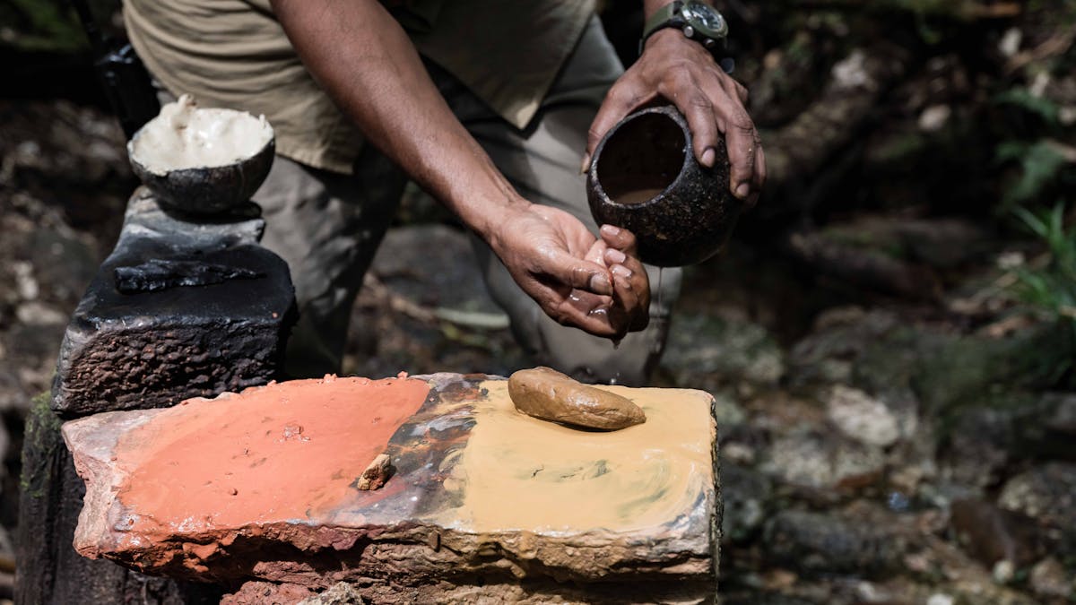 Guided washing hand with water after painting with ochre