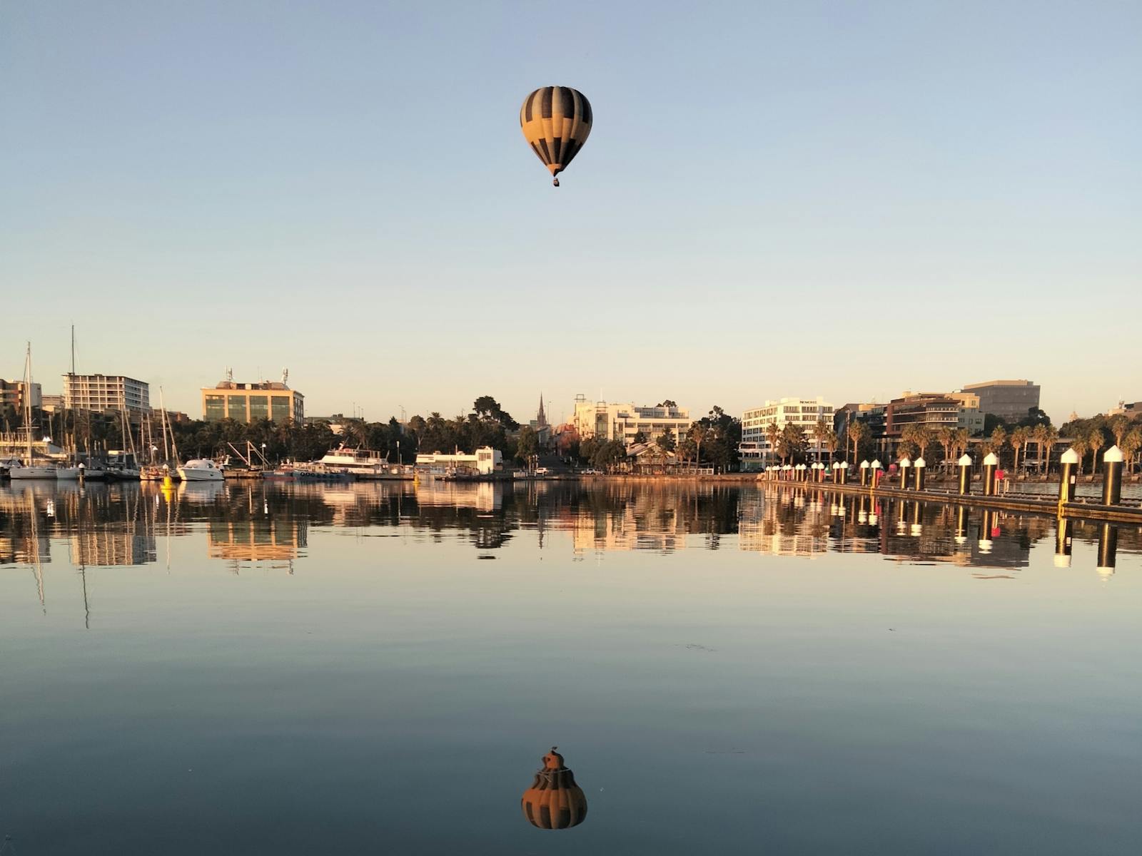 Balloon over the peir with the shimmering reflection below.