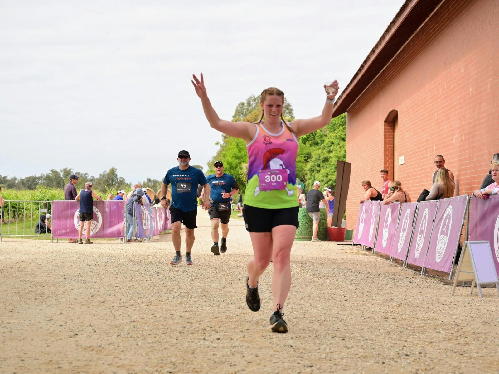 Runner crossing the finish line with a glass of wine.