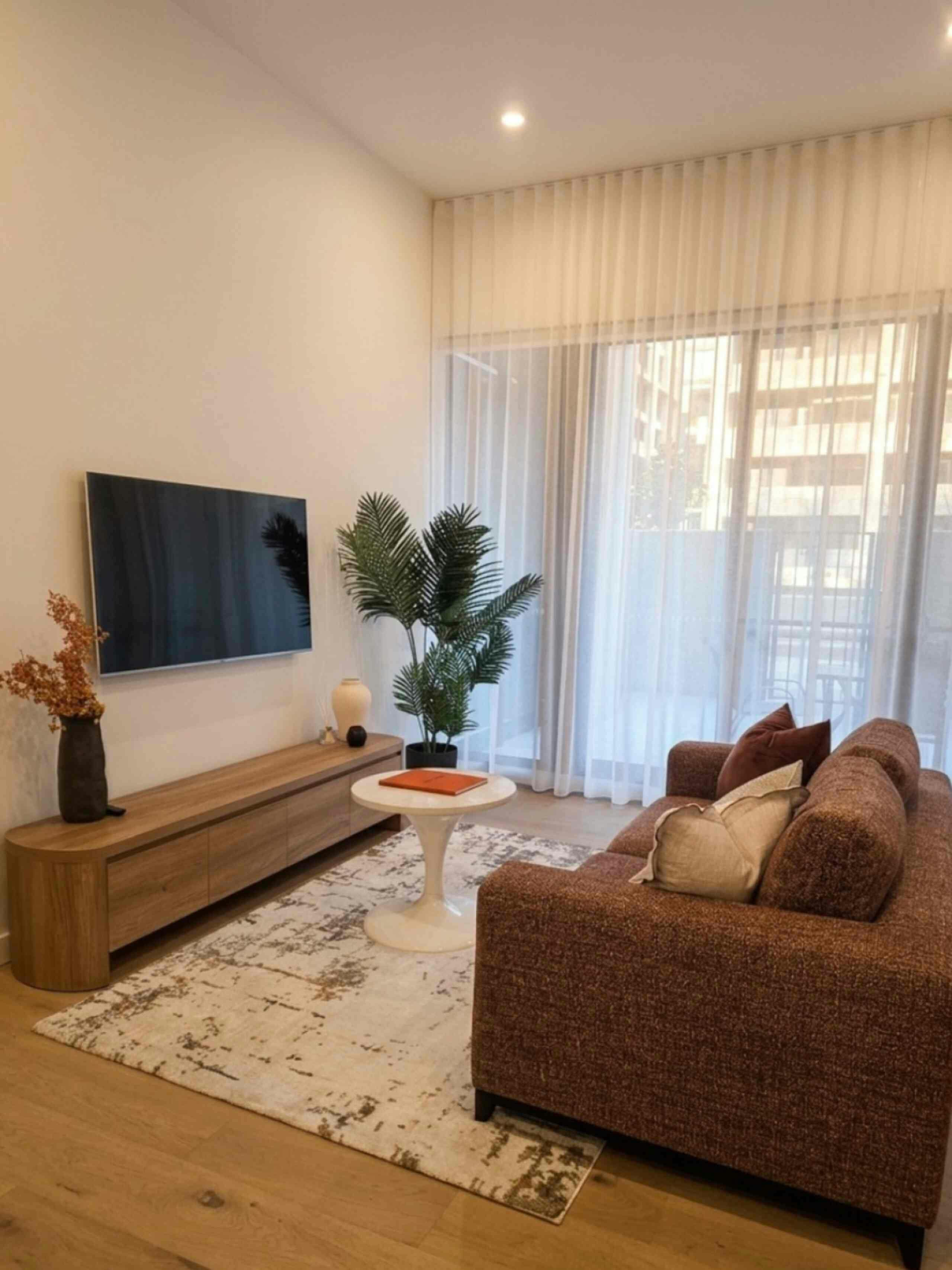 Cozy living space featuring ample natural light from windows and an entertainment center with a tele