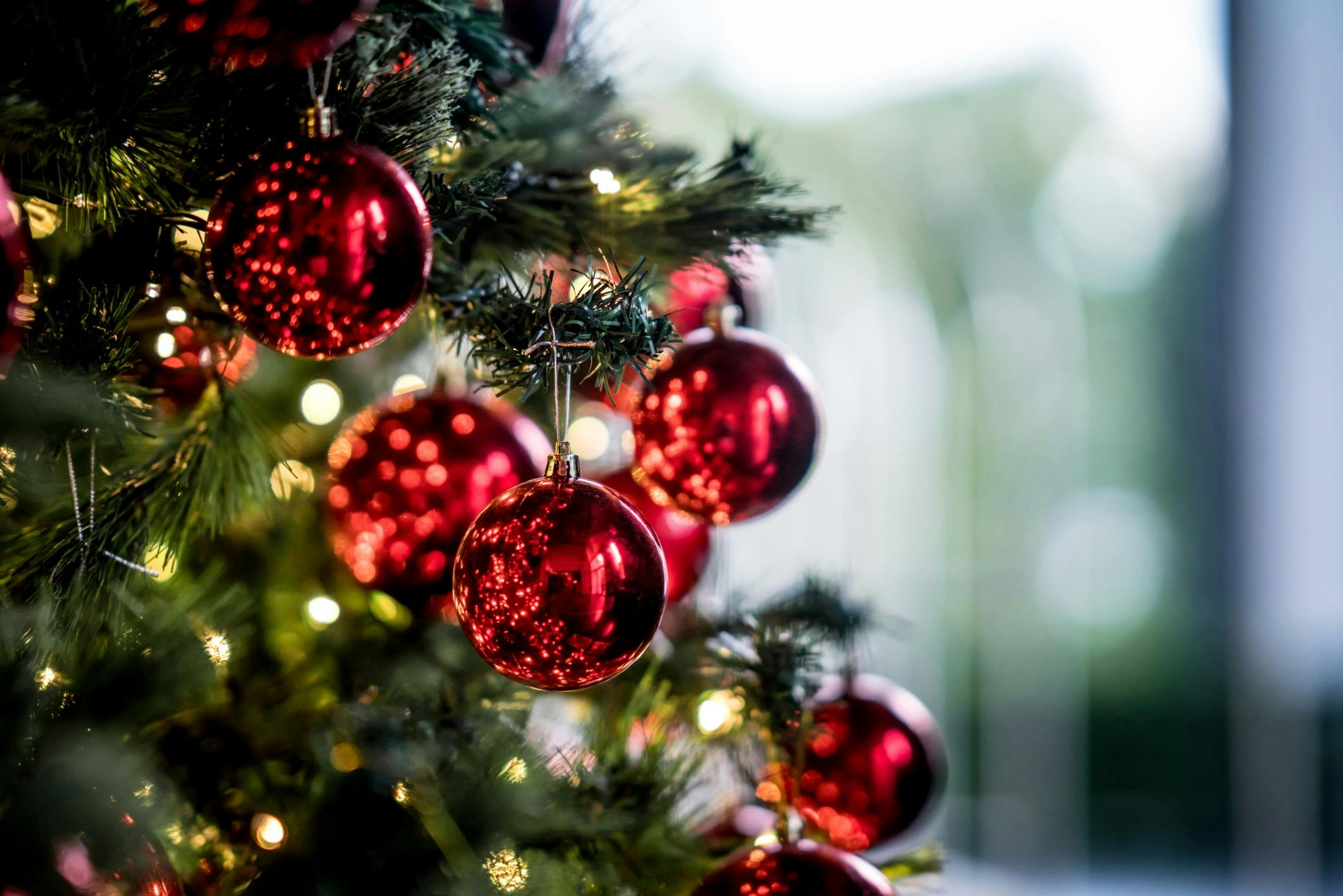 A close up of a decorated Christmas tree with Red baubles.