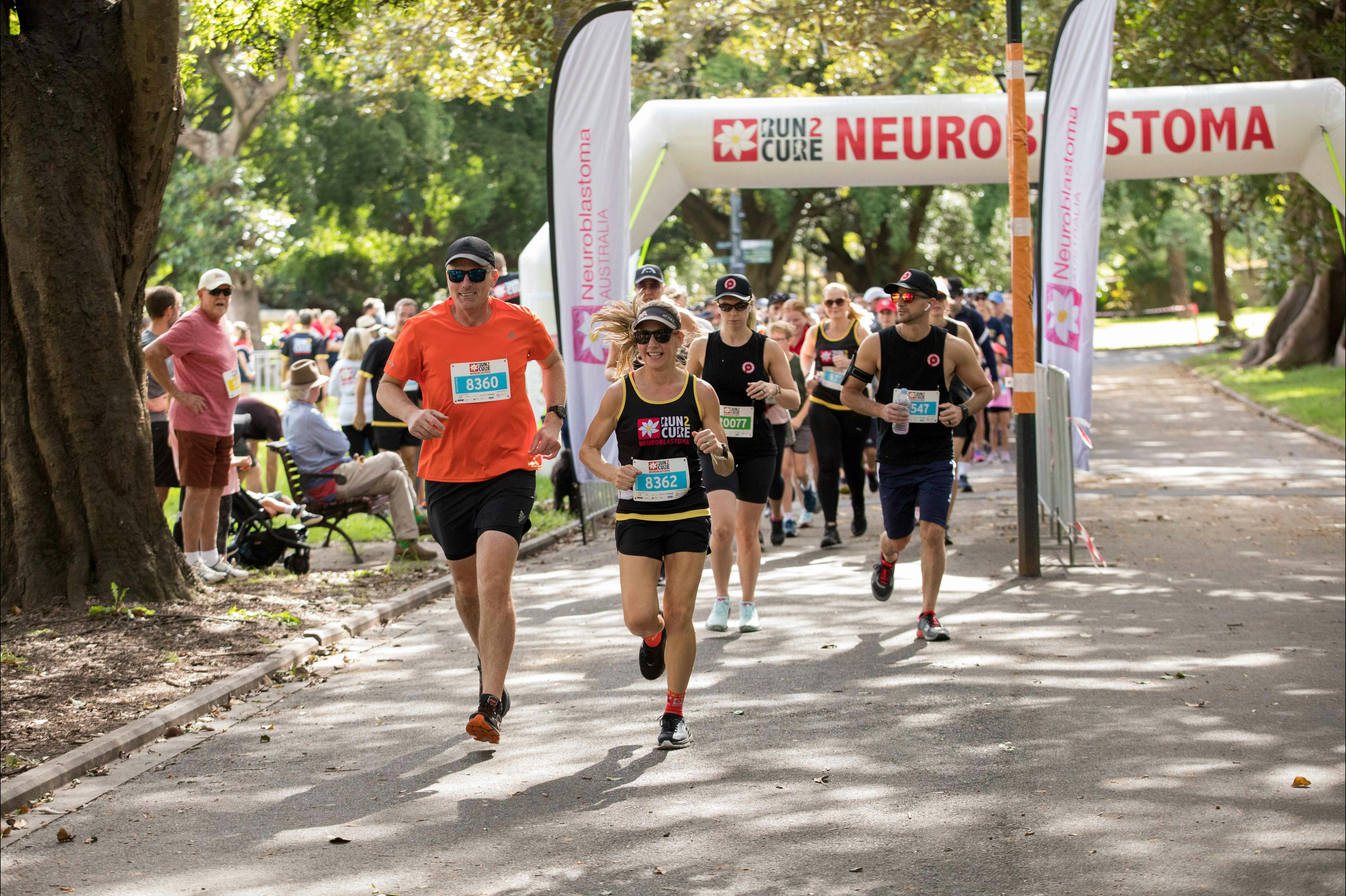 Runners leading the pack at the start of Run2Cure under the neuroblastoma event arch