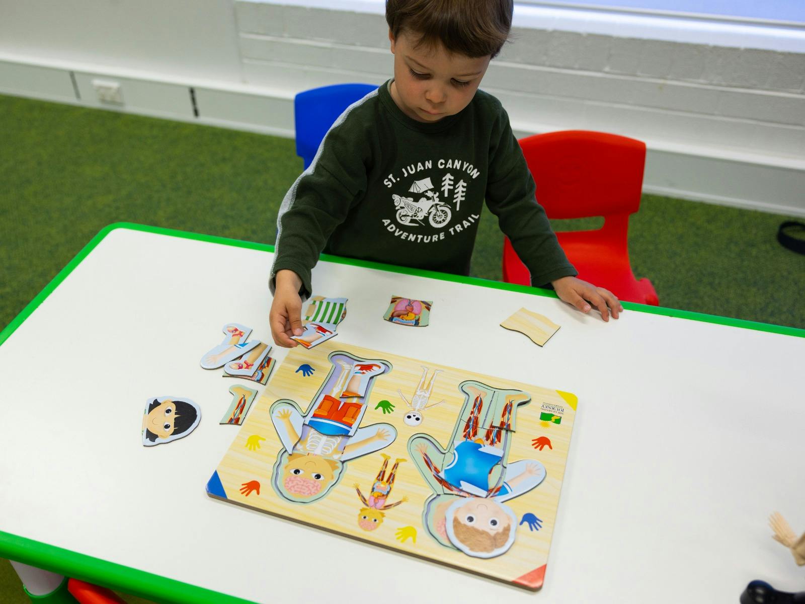 A young boy completing a human body puzzle