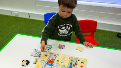 A young boy completing a human body puzzle
