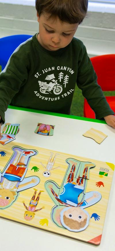 A young boy completing a human body puzzle