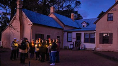 Group attending Stories at Sunset holding lanterns in the Lanyon Homestead courtyard